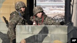 South Korean army soldiers stand guard at a military checkpoint near the border village of Panmunjom, which has separated the two Koreas since the Korean War, in Paju, South Korea, Dec. 13, 2103.