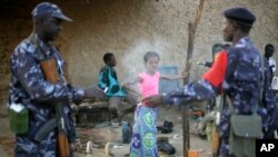 A young girl's face is engulfed in smoke as Malian soldiers patrolling with Tuareg Malian soldiers under the command of Colonel El-Hadj Ag Gamou stop for a cigarette break in the streets of Gao, northern Mali, Feb. 16, 2013. 