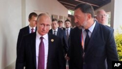 Russia's President Vladimir Putin, left, and Russian metals magnate Oleg Deripaska, right, walk to attend the APEC Business Advisory Council dialogue in Danang, Vietnam, Nov. 10, 2017. 