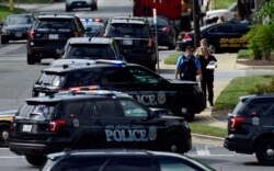 FILE - Police secure the scene of a shooting at the building housing the Capital Gazette newspaper in Annapolis, Md., June 28, 2018.