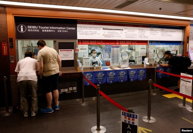 German tourist Kevin Khani and Austrian tourist Georg Riedlbaur use an automated translation window at the Seibu-Shinjuku station in Tokyo, Japan, July 26, 2023. (REUTERS/Kim Kyung-Hoon)