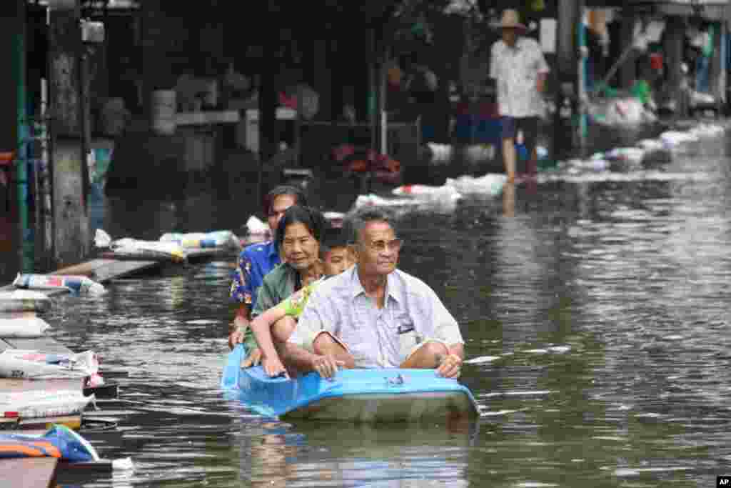 A family boating out of their flooded neighborhood, Ayutthaya, Thailand, October 6, 2011. (VOA - D. Schearf)