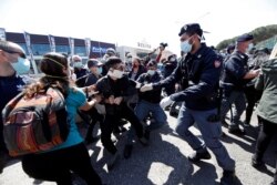 Police surround protesters wearing protective face masks as they demonstrate outside the Rebibbia prison to demand better sanitary conditions for prisoners inside the jail in Rome, Italy, April 16, 2020.