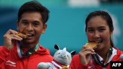 Aldila Sutjiadi (kanan) dan Christopher Benjamin Rungkat (kiri) berpose dengan medali emas dari cabor tenis, final nomor ganda campuran di Asian Games, Palembang, 25 Agustus 2018.