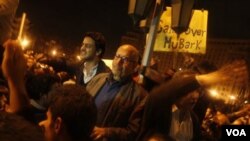 Mantan Ketua IAEA dan penerima Nobel perdamaian, Mohamed ElBaradei (tengah, berkacamata) bergabung dengan para demonstran di Lapangan Tahrir, Kairo, Minggu 30 Januari 2011.