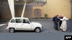 This handout picture released by the Vatican Press Office shows Father Don Renzo Zocca (2ndR) offering his white Renault 4L to Pope Francis during a meeting at the Vatican, Sept. 7, 2013. (AFP photo/Osservatore Romano)