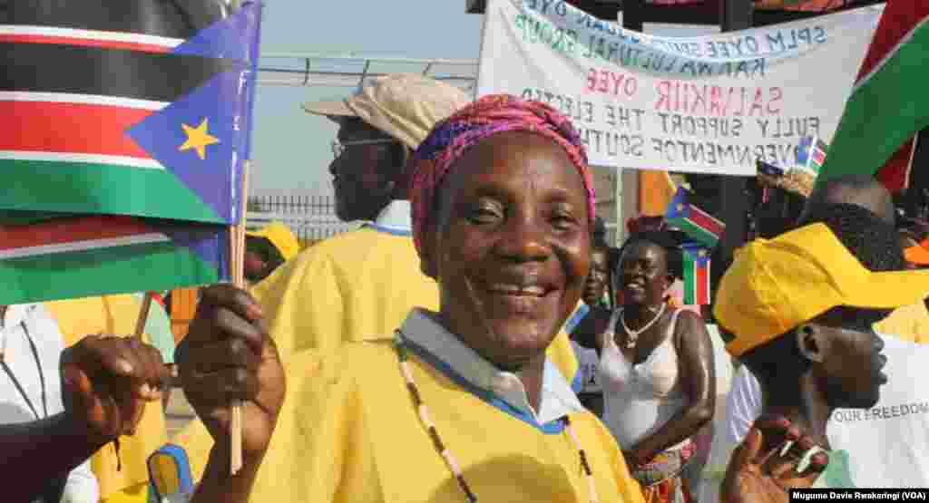A woman holds three South Sudanese flags at an event in Juba to mark the fourth anniversary of independence of the world&#39;s newest nation.