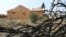 In this Aug. 9, 2018 photo, a burned tree sits in the foreground of Cheri Sharp's new home under construction in Santa Rosa, Calif. After she lost her home in the deadly October 2017 wildfires, Sharp discovered her insurance policy didn't cover the actual cost of rebuilding the house.