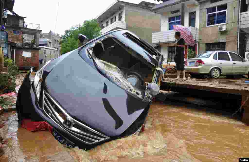 A car is stuck in a flooded river after a heavy rainfall in Dexing, Jiangxi province, China.