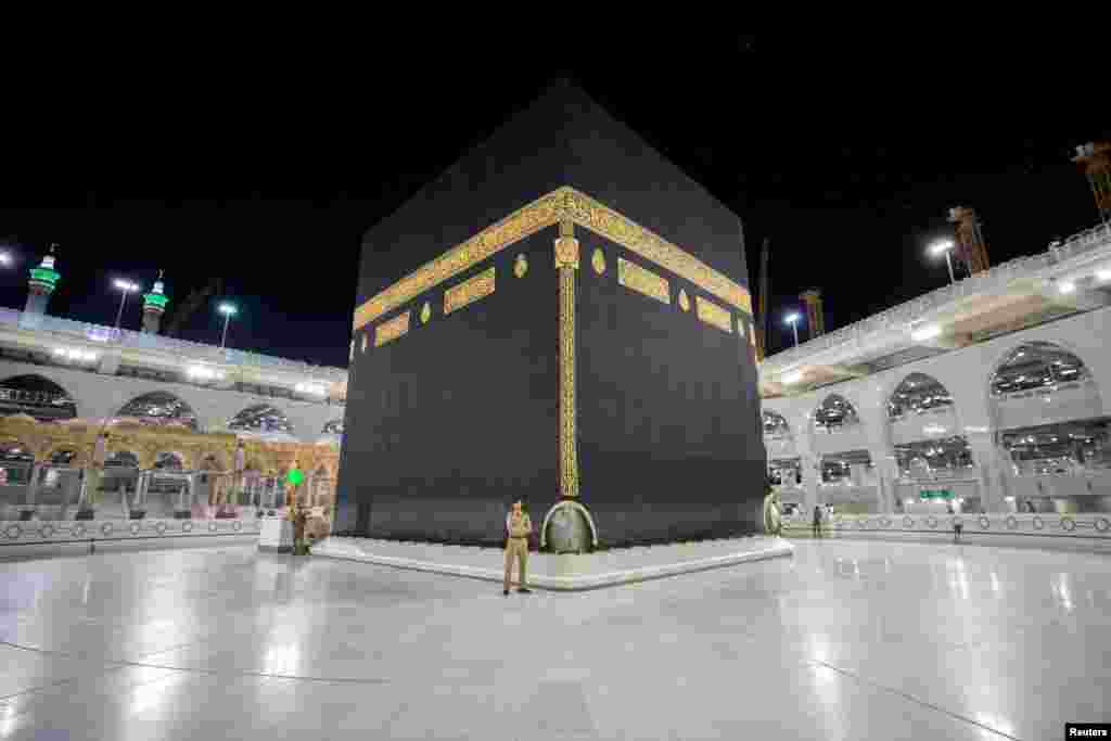 Saudi security officers stand in front of the Kaaba at empty Grand mosque, as a preventive measure against the coronavirus disease (COVID-19), during the holy month of Ramadan, in the holy city of Mecca, Saudi Arabia.