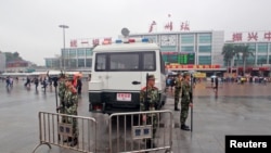 Polisi paramiliter China berpakaian seragam anti huru-hara, berjaga di depan stasiun kereta api Guangzhou pasca serangan pria bersenjata pisau (6/3).