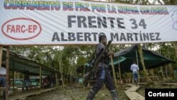 Un guerrillero pasa por delante de un cartelke identificativo de las FARC en momnetos en que no se habían dsmovilizado.Archivo.