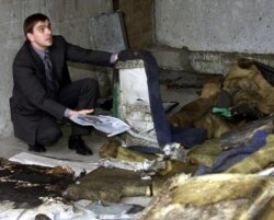 FILE - Viacheslav Filev, general director of Russia's Sibir airlines, shows a perforated seat of the crashed Tupolev TU-154 plane, in a hangar of Adler airport, Oct. 6, 2001.