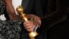 Cynthia Erivo, left, and Jon M. Chu pose with the award for cinematic and box office achievement for "Wicked" in the press room during the 82nd Golden Globes, Jan. 5, 2025, at the Beverly Hilton in Beverly Hills, Calif. 