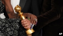 Cynthia Erivo, left, and Jon M. Chu pose with the award for cinematic and box office achievement for "Wicked" in the press room during the 82nd Golden Globes, Jan. 5, 2025, at the Beverly Hilton in Beverly Hills, Calif. 