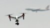 FILE - A drone flies in Hanworth Park in west London as a British Airways plane in the background prepares to land at Heathrow Airport, Feb. 25, 2017. Britain's aviation regulator said Oct. 14, 2024, that it would allow drones to inspect infrastructure.