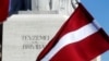 Latvia's national flag flutters next to the Freedom monument in Riga, Latvia, March 16, 2018. 