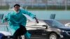 Richardson Fremond leaps over a wall as he runs to collect an award during a graduation ceremony for the senior class of Chambers High School at Homestead-Miami Speedway, in Homestead, Fla., June 23, 2020.