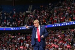 FILE - President Donald Trump points at the crowd as he enters his first re-election campaign rally in several months in the midst of the coronavirus disease (COVID-19) outbreak, at the BOK Center in Tulsa, Okla., June 20, 2020.
