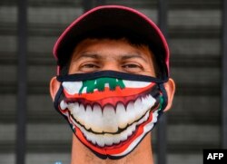 A street vendor wearing a face mask poses outside the central market in San Salvador on May 6, 2020, amid the COVID-19 coronavirus pandemic. (Photo by Yuri CORTEZ / AFP)