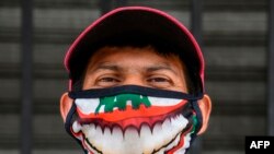 A street vendor wearing a face mask poses outside the central market in San Salvador on May 6, 2020, amid the COVID-19 pandemic. 