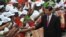 Chinese President Xi Jinping (R) shakes hand with traditional dancers upon his arrival at Julius Nyerere International airport in Dar es Salaam, Tanzania, March 24, 2013.