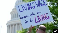 A person holds up a sign during the "Poor People's Campaign: A National Call for Moral Revival" on Capitol Hill in Washington, May 14, 2018. 