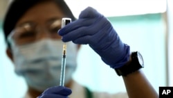 A medical worker fills a syringe with a dose of the Pfizer-BioNTech COVID-19 vaccine at Tokyo Medical Center.(Behrouz Mehri/Pool Photo via AP)