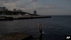 Seorang anak laki-laki menyelam ke dalam air di objek wisata pantai populer di sepanjang pantai Laut Hitam di Odesa, Ukraina, Minggu, 23 Juli 2023. (Foto: AP)