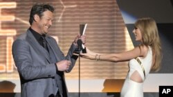 Taylor Swift, derecha, entrega el premio de Vocalista del año a Blake Shelton en 2012. Ambos están nuevamente entre los nominados.