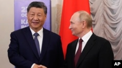 Prezidan Ris Vladimir Putin (a dwat) ak Prezidan Lachin Xi Jinping bay lanmen pandan rankont yo sou kote rankont o some BRICS la nan Kazan, La Risi, 22 Oktob, 2024. 