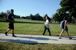 FILE - A student from China, center, walks on campus at the University of Connecticut, in Storrs, Connecticut, Sept. 18, 2015.