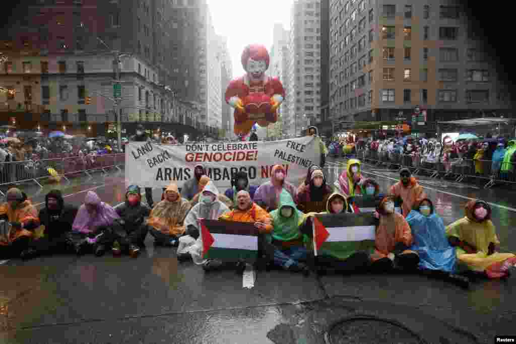 La policía de Nueva York dijo que arrestó a 21 personas después de que los manifestantes se sentaran en la ruta del desfile con banderas y una pancarta que decía &quot;No celebren el genocidio&quot;.