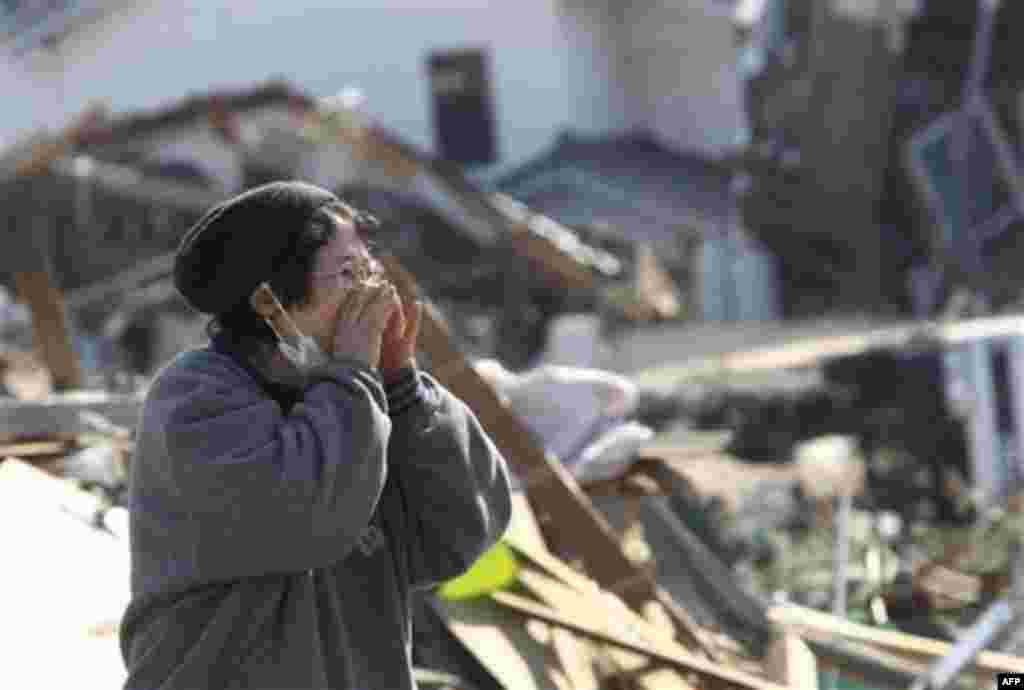 A woman yells a name of her missing family in Soma in Fukushima Prefecture Monday, March 14, 2011, three days after a powerful earthquake-triggered tsunami hit the country's northeast coast. (AP Photo/The Yomiuri Shimbun, Kazuki Wakasugi) JAPAN OUT, CREDI