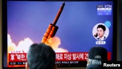 FILE - People watch a TV showing a file picture for a news report on North Korea firing two unidentified projectiles, in Seoul, South Korea, March 2, 2020.