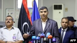 Le ministre de l'Intérieur libyen (GNA), le ministre de l'Intérieur Abdessalam Achour (C) et le sous-secrétaire du ministère des Communications du gouvernement GNA Hisham Abu Shkiwat (R) donnent une conférence de presse au cours de laquelle ils ont dévoil