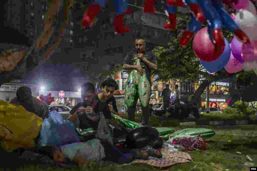 Penjual balon bersiap-siap sebelum jemaah sholat Idul Fitri tiba di Kairo, Mesir, 25 Juni 2017. (H. Elrasam/VOA)