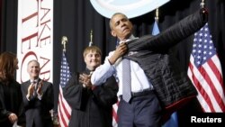 Presiden AS Barack Obama menerima jaket almamater dari Lake Area Technical Institute di Watertown, South Dakota (8/5) usai memberikan pidato kelulusan. (Reuters/Jonathan Ernst)