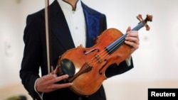 Violist David Aaron Carpenter of the U.S. holds the 'Macdonald' Viola by Antonio Stradivari, made in 1719, at Sotheby's gallery in New York, March 27, 2014.