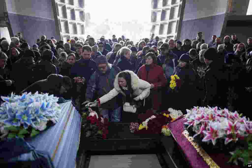 People attend the funeral ceremony of neurobiologist Ihor Zyma and his wife, biologist Olesia Sokur, who were killed by a Russian strike on Jan. 1, in Kyiv, Ukraine.