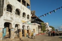 FILE - People walk along the streets in Kenya's resort town of Lamu.