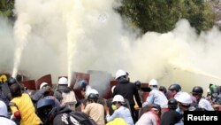 Gas air mata dan gas pemadam kebakaran di sekitar demonstran selama protes terhadap kudeta militer di Naypyitaw, Myanmar, 8 Maret 2021. (Foto: Reuters)