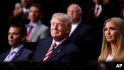 FILE - Donald Trump, then a Republican presidential candidate. watches with Donald Trump Jr., left, and Ivanka Trump as son Eric Trump addresses delegates during the Republican National Convention in Cleveland, July 20, 2016. 