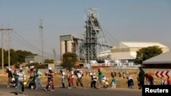 Members of the mining community carry donated food parcels at the Khomanani mine in Rustenburg, South Africa, May 28, 2014. 