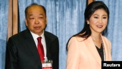 PM Thailand Yingluck Shinawatra (kanan) dan wakilnya, Surapong Tovichakchaikul tiba di Akademi Angkatan Udara Kerajaan Thailand di Bangkok, sesaat sebelum dimulainya pertemuan dengan Komisi Pemilu Thailand (30/4).