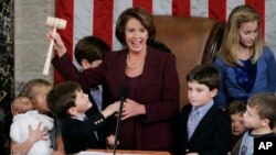 In this Jan. 4, 2007 file photo, newly-elected Speaker of the House Nancy Pelosi, holds up the gavel surrounded by children and grandchildren of members of Congress in the U.S. Capitol in Washington. Pelosi was the first woman elected as Speaker. (AP File Photo/Pablo Martinez Monsivais)