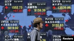 A man walks past a stock quotation board outside a brokerage in Tokyo, Japan, September 14, 2012. 