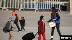 FILE - Migrant children from Central America walk at the Leona Vicario temporary migrant shelter before being transferred to continue their asylum request in the U.S., in Ciudad Juarez, Mexico, Feb. 26, 2021.