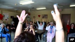 La asistente de enfermería Dulce Torres dirige a ancianos durante una sesión de ejercicios físicos en el Centro de Actividades y Nutrición de la Pequeña Habana. Marzo 4 de 2020.