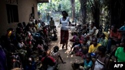 A volunteer brings daily food rations for internally displaced persons (IDPs), at a camp for IDPs fleeing the conflict in the DRC's Kasai province, June 7, 2017, in Kikwit, DRC. 